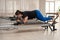 Overweight caucasian woman doing pilates exercises on a reformer.