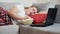 Overweight girl sleeping on a sofa in front of a laptop