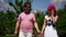 Overweight man and slender woman are walking together in summer day, holding hands and laughing