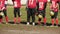 Overweight man standing in line with American football team players, obesity