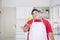 Overweight man throws up a paprika in the kitchen