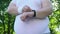 Overweight man turns on timer on his smart watch, beginning of daily training