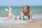 Overweight woman in bikini lying on front in sea foam