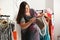 Overweight woman choosing bag in shop