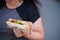 Overweight woman eating sandwich walking outdoors