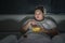 Overweight woman enjoying popcorn in bedroom