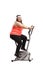 Overweight woman exercising on a stationary bike and looking at