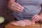 Overweight woman hands adding salt to raw chicken breasts. Dieti