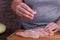 Overweight woman hands adding salt to raw chicken breasts. Dieti