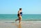 Overweight woman running on beach