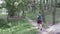 Overweight woman running in forest. Obese girl jogging training in park along path, persistent attempts to lose weight
