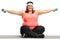 Overweight woman seated on an exercise mat exercising with small