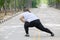 Overweight woman stretching her legs on road