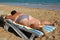 Overweight woman sunbathe on beach