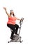 Overweight woman working out on an exercise bike and waving