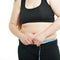 Overweight young woman measuring her waist, isolated over white background. Overeating xl size woman