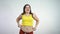 Overweight young woman wiggled her belly and smiling. Body positive concept