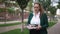 Overwhelmed Caucasian obese businesswoman standing on sidewalk with paperwork looking around. Portrait of stressed