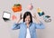 Overwhelmed woman and different objects around her on light grey background