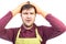 Overwhelmed young man with apron and gloves holding hands on hea