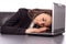 Overworked businesswoman sleeping on her laptop being exhausted