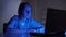 Overworked female nurse sobbing sitting in front laptop in dark room, stress