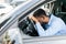 Overworked personal african man driver falling asleep on steering wheel of car, tired man