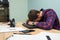 Overworked tired manager sleeping on the desk after a hard day at work. Tired man falls asleep in the workplace. Business startup