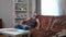 Overworking freelancer closing laptop sighing leaning back on sofa sitting in living room at home. Wide shot portrait of