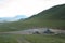 Ovoo in the mountains of Mongolia on the pass. Car with a trailer, motorcyclist and passenger car nearby