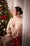 Owerweight elegant Woman at Christmas room. Fat plumb pretty girl in a beautiful dress for a holiday. Popular buxom