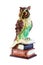 Owl as symbol of wisdom and knowledge. Decorative item, statuette of owl on stack of books. Isolated, white background