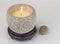 Owl shape decorative candle lit with pebble next to it isolated