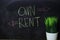 Own or Rent written with color chalk concept on the blackboard