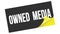 OWNED  MEDIA text on black yellow sticker stamp