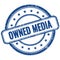 OWNED MEDIA text on blue grungy round rubber stamp