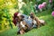 Owner laying on a meadow with cute brown Boxer Dogs