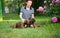 Owner laying on a meadow with cute brown Boxer Dogs