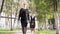 Owner leads the Eastern European Shepherd on a leash in the park. Girl in black clothes with a sheepdog on a leash. High