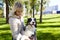 Owner plays with a siberian laika dog in autumn park