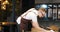 Owner of restaurant, waiter in cafe is cleaning tables before opening in morning