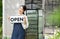 The owner of the tree shop holds a open sign after a long time closed. Cute asian gardener small business open her shop selling