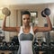 Owning this workout. Shot of a young woman working out with dumbbells at the gym.