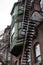 Oxidized copper detail on rear of brownstone rowhouse metal fire escapes