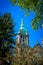 Oxidized copper gable of the cathedral of Saint-Hyacinthe seen between the foliage of the trees