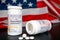 Oxycodone Hydrochloride prescription bottles isolated on black foreground with the american national flag in the background.