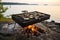 oysters grilling on a portable barbecue near the ocean