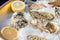 Oysters, halves of the lemon on ice, detail image.