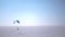PA paraglider soars over the frozen lake right on the horizon. HD 1080p.