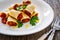 Paccheri con rag alla bolognese - noodles with bolognese sauce on wooden table